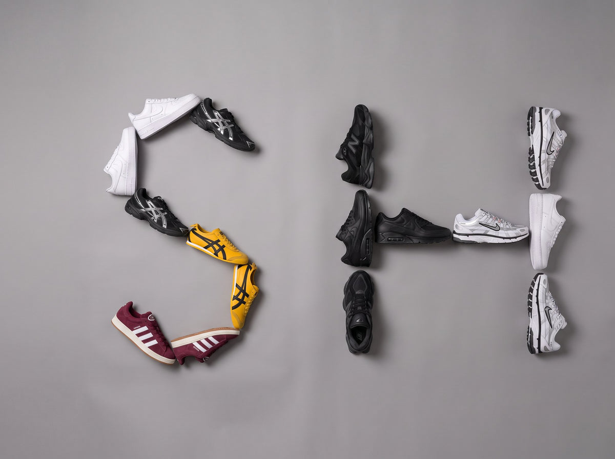 Sneakers op een grijze vloer, gelegd als de letters SH